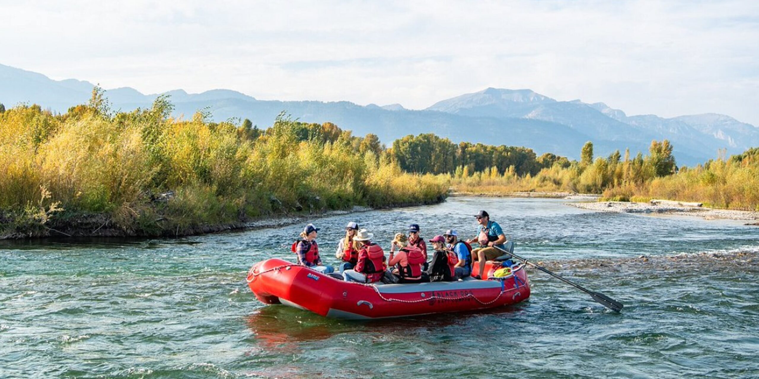 Group floating in a red raft down the Snake River in Jackson Hole